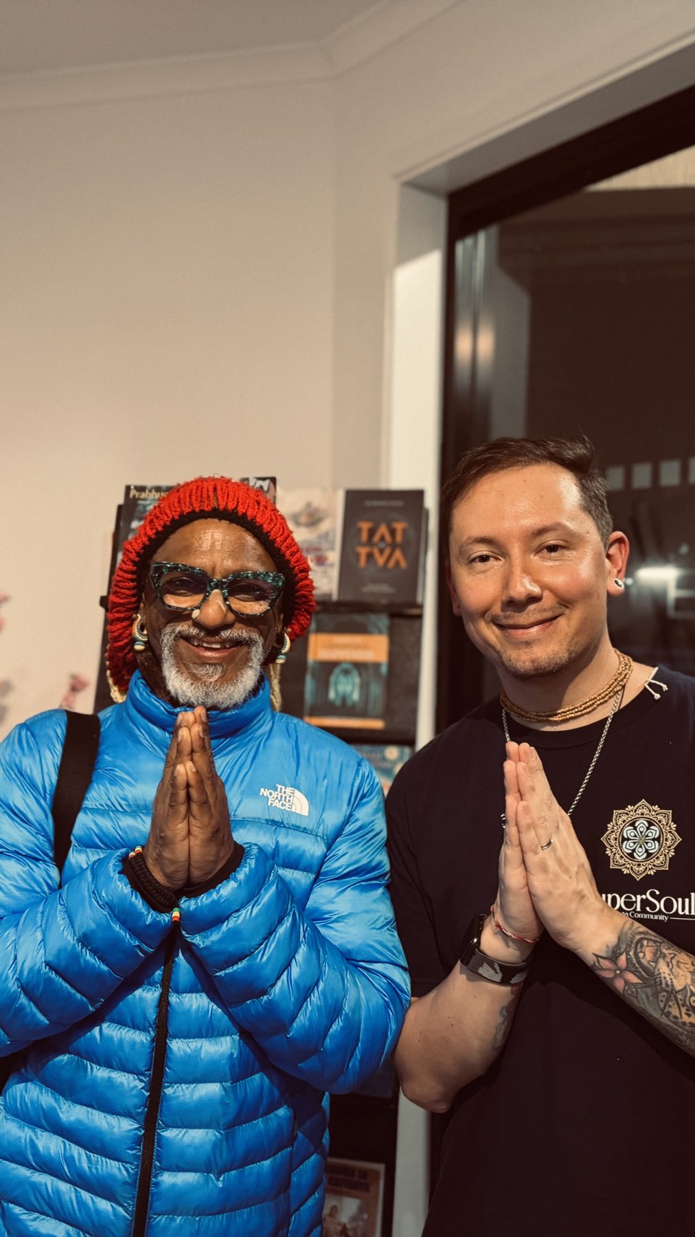 Two kirtaneers smiling with hands in prayer position
