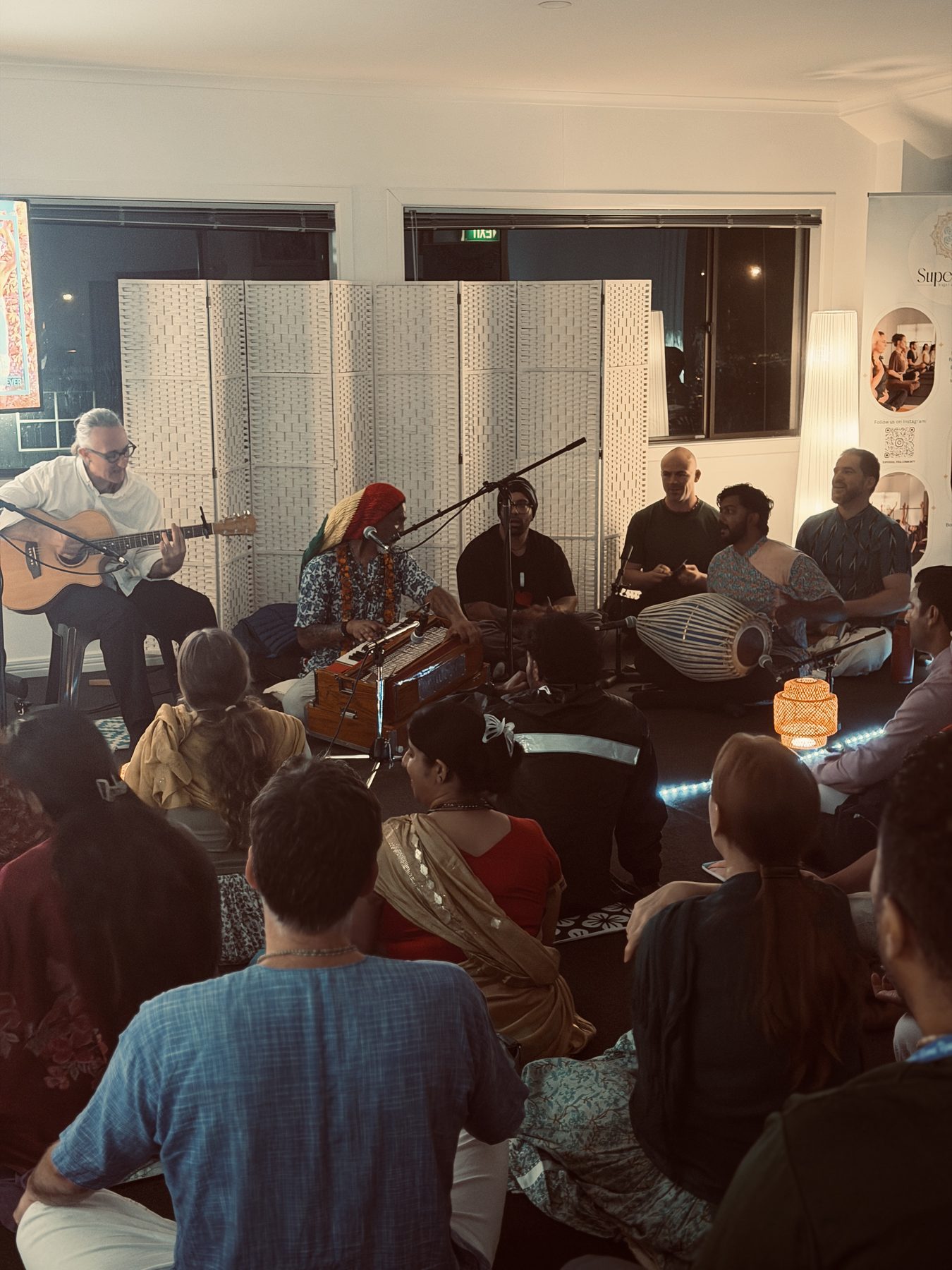 A group of people playing music together during kirtan
