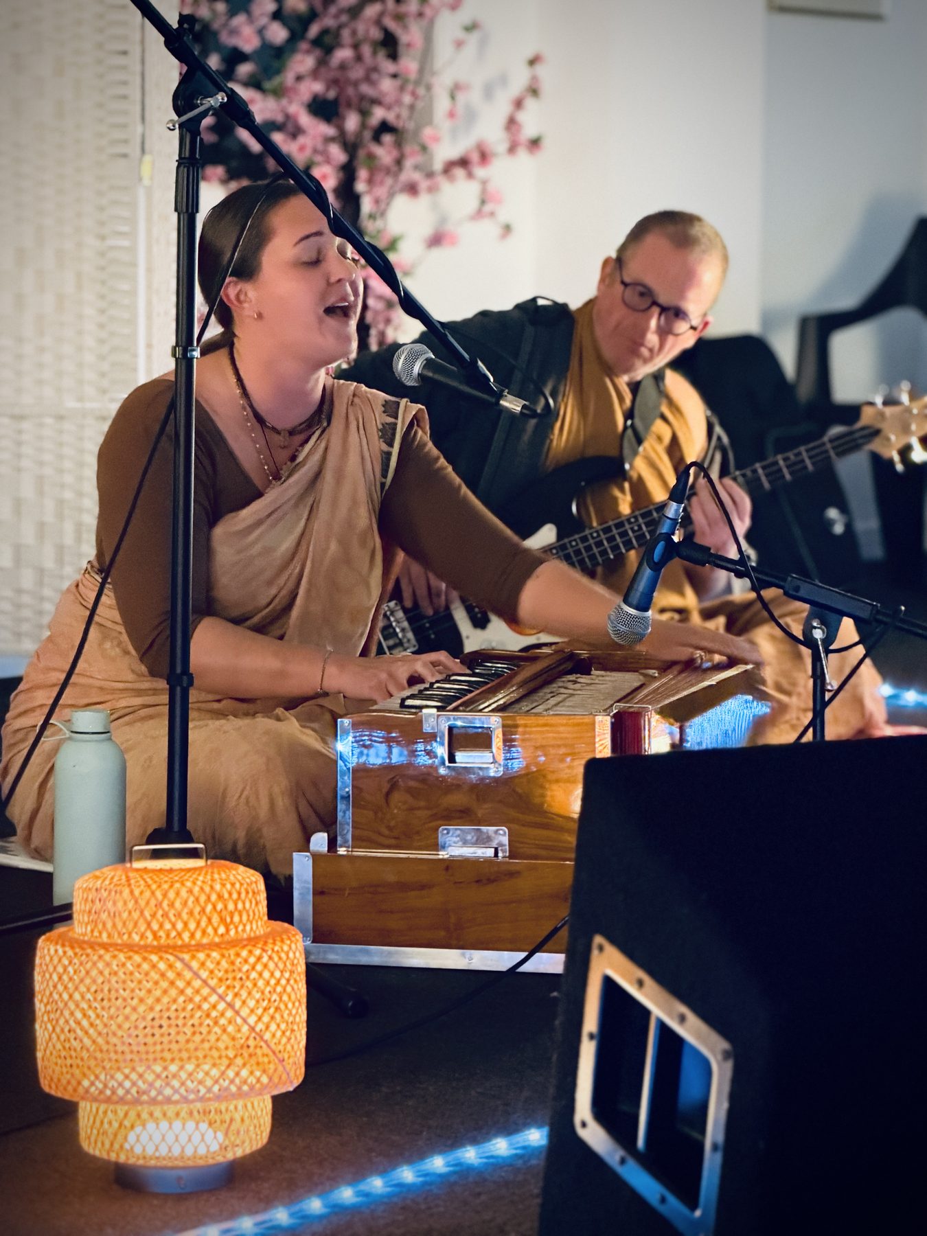 People singing and playing instruments during a kirtan session
