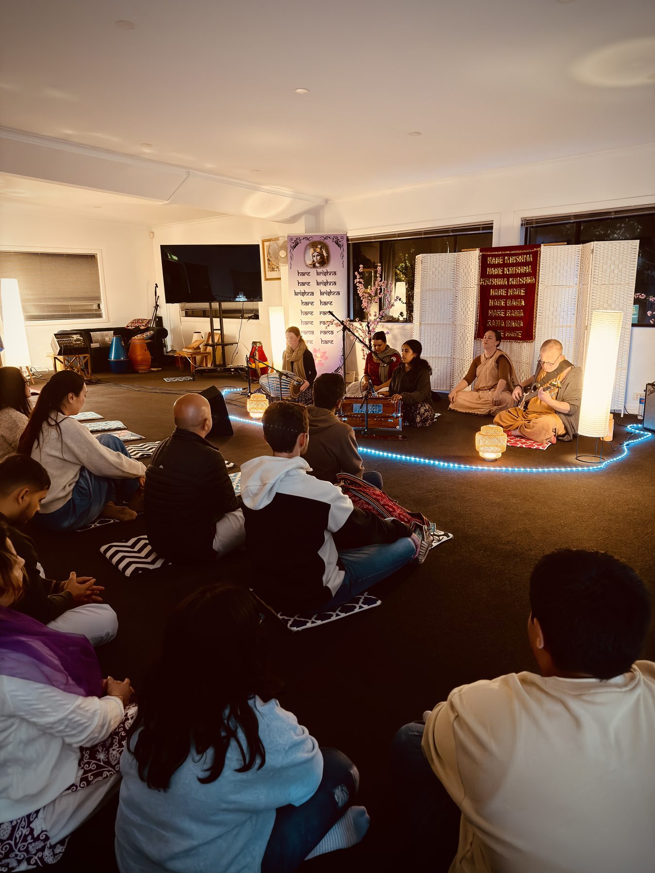 A group of people sitting in a circle playing music