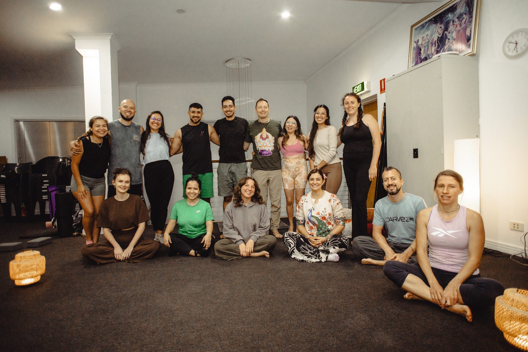A group of people sitting on the floor in the yoga studio