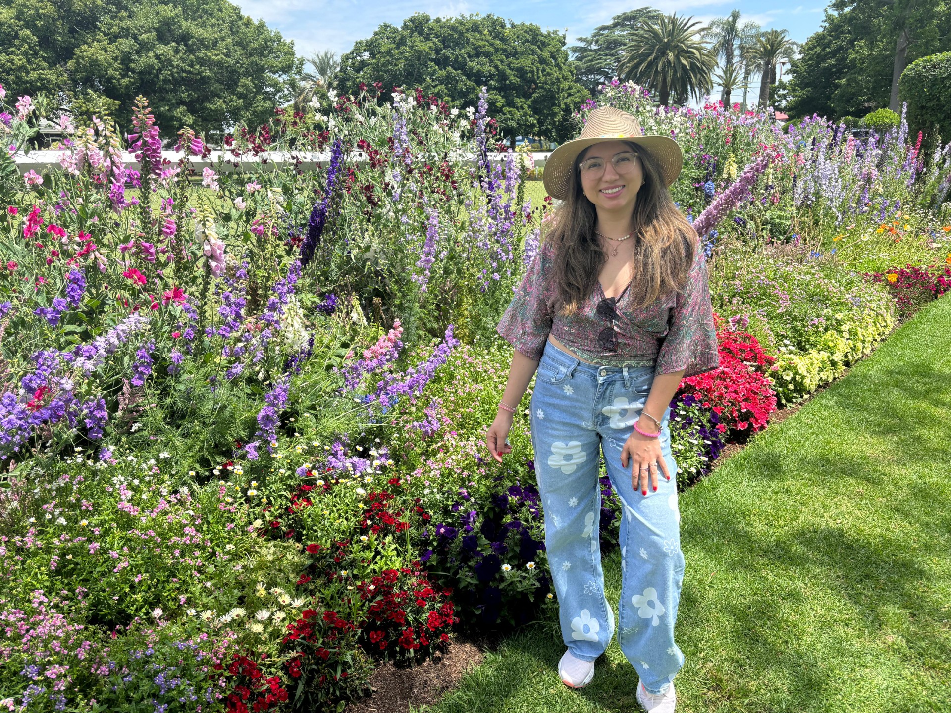 Melissa Acosta standing beside a flower garden